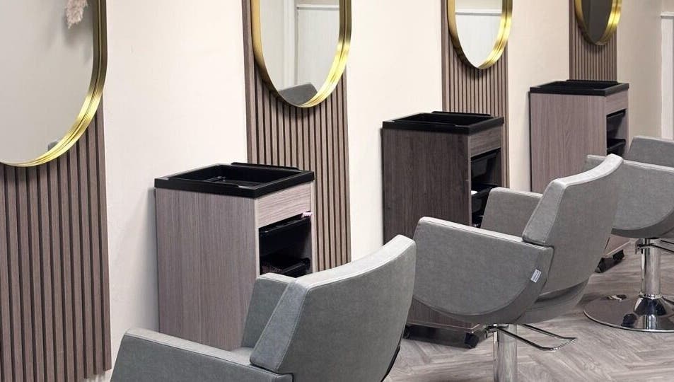 Modern salon chairs and mirrors at Caine Moore Hair, Egremont, England, GB, showcasing sleek design.