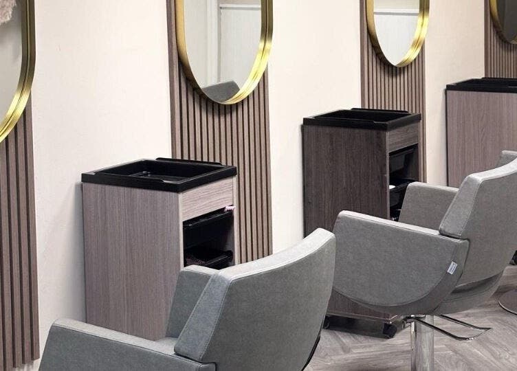 Modern salon chairs and mirrors at Caine Moore Hair, Egremont, England, GB, showcasing sleek design.