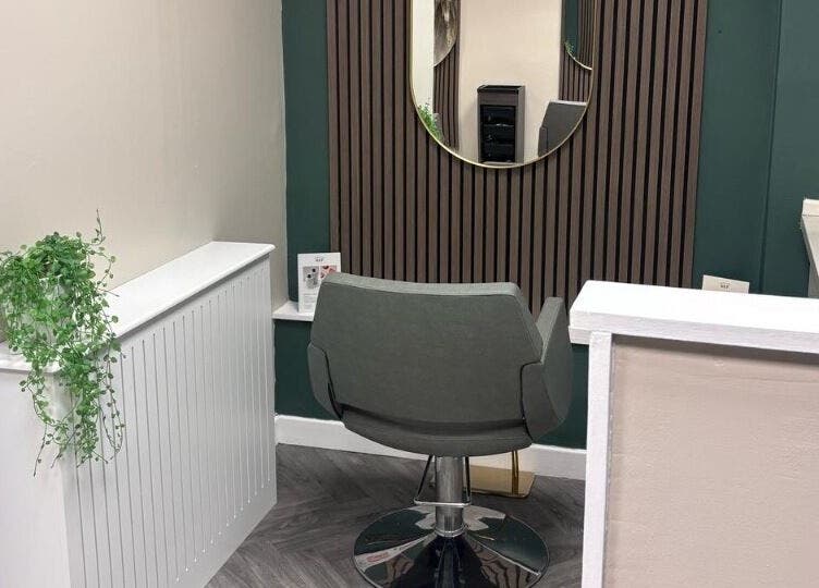 Elegant styling area at Caine Moore Hair, Egremont, England, GB, with modern chair and decor.