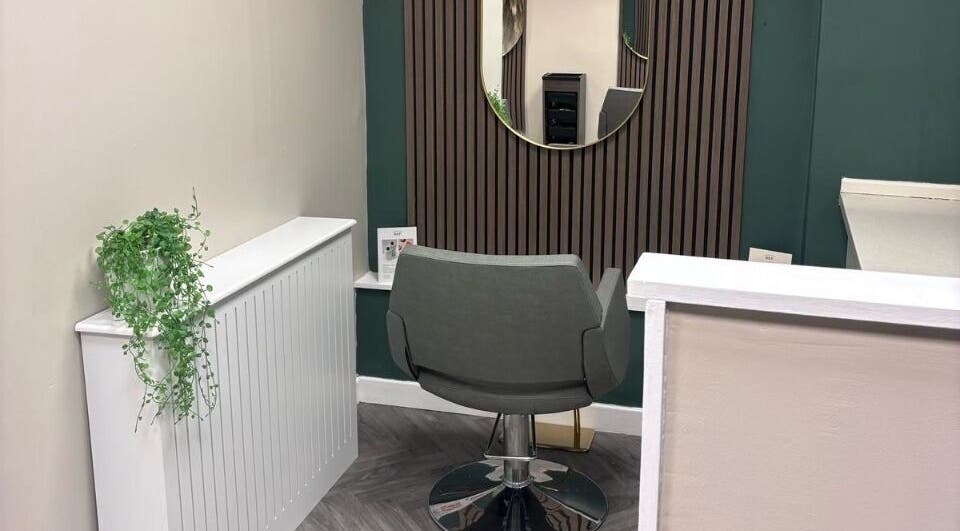 Elegant styling area at Caine Moore Hair, Egremont, England, GB, with modern chair and decor.