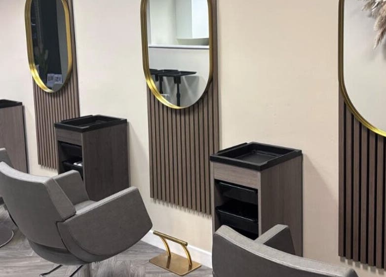 Elegant hair styling stations at Caine Moore Hair, Egremont, England, GB, featuring modern mirrors.