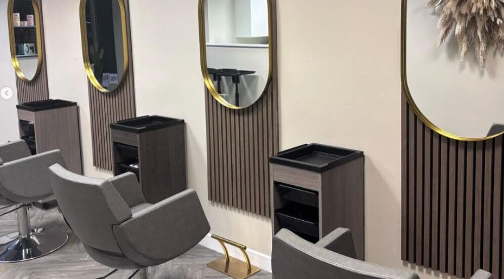 Elegant hair styling stations at Caine Moore Hair, Egremont, England, GB, featuring modern mirrors.