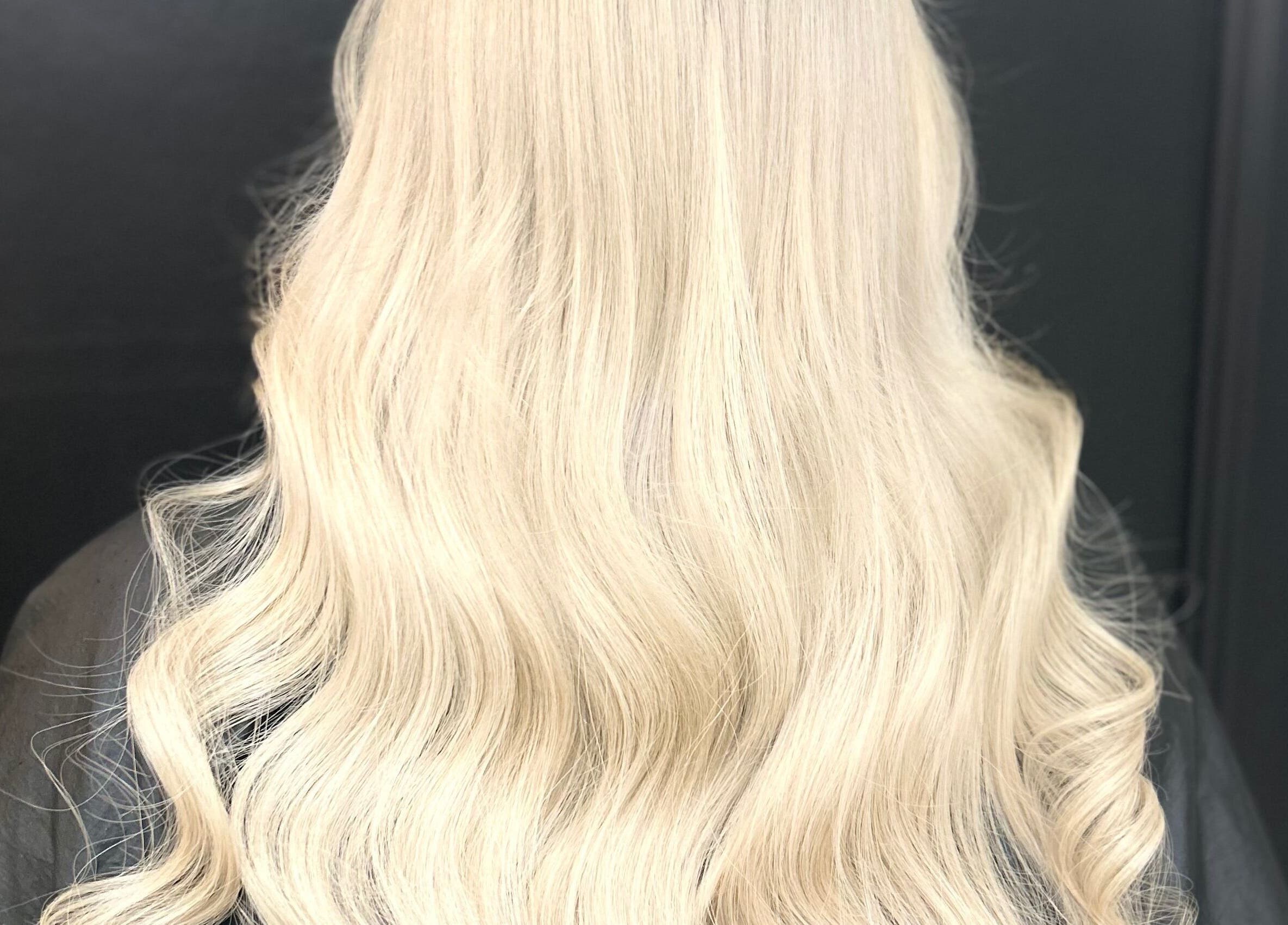 Elegant blonde waves styled by Caine Moore Hair in Egremont, England, GB.
