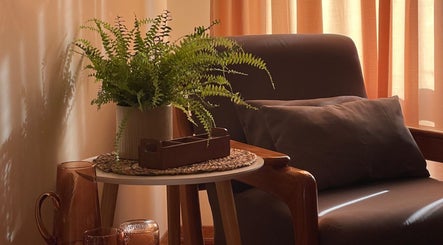 Espaço acolhedor no Rosalusa • Massagem e Bem-estar, Costa Da Caparica, Setúbal, PT, com cadeira e planta.