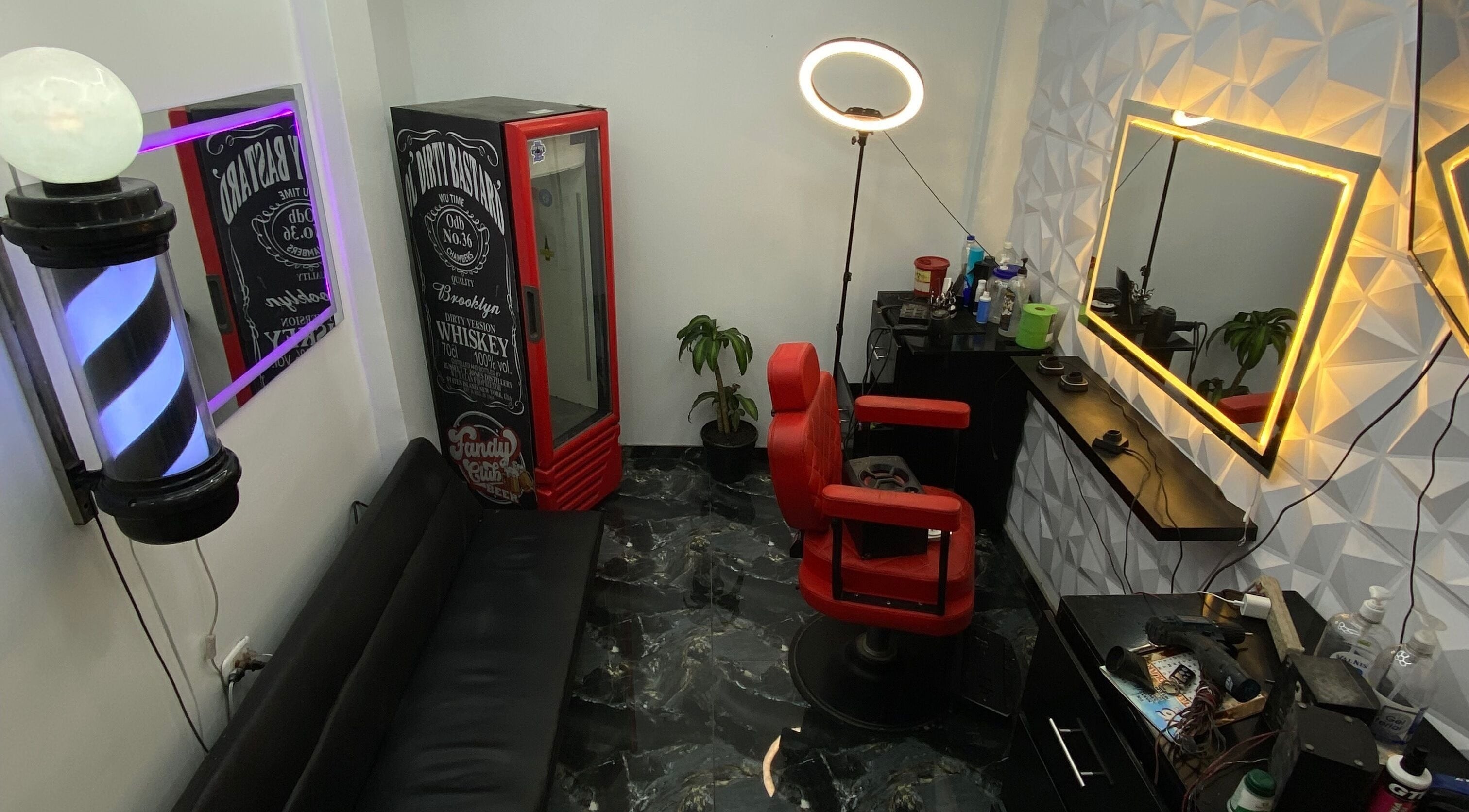 Interior moderno de Barberia Fandy Club, Soacha, Cundinamarca, CO, destacando sillón rojo y decoración contemporánea.