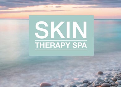 Serene beach view with 'Skin Therapy Spa - Denia' logo in Denia, Alicante, ES.
