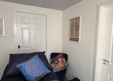 Chic therapy room at Natural Balance Holistic Therapy, Allerton Bywater, England, featuring vibrant art and cozy seating.