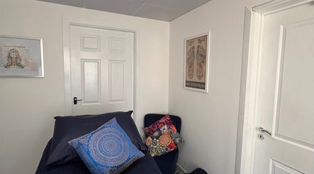 Chic therapy room at Natural Balance Holistic Therapy, Allerton Bywater, England, featuring vibrant art and cozy seating.