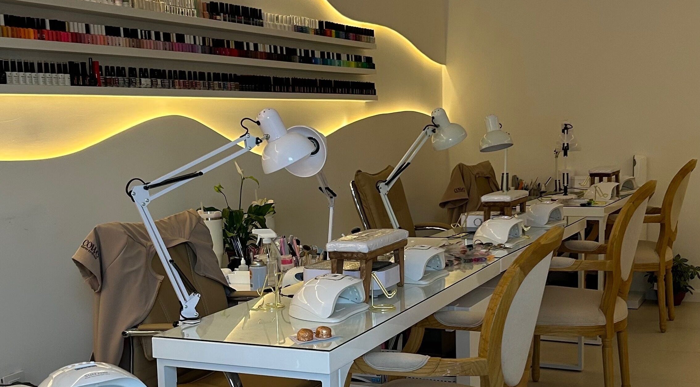 Mesa de manicura de COWE Centro Estético en San Carlos, Departamento De Maldonado, UY, con lámparas y esmaltes.