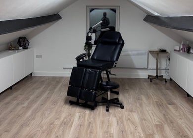 Modern treatment room at Kate's Studio, Coalville, England, GB with a sleek black chair and stylish decor.