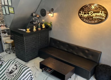 Reception area of Hair Republic Barber Salon and Spa, Calamba Branch, featuring sleek decor and comfy seating.