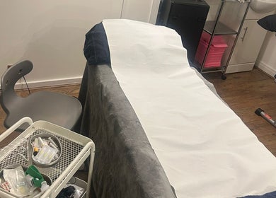 Treatment room at AMORE Aesthetics, London, England, GB, showcasing a well-prepared beauty bed.