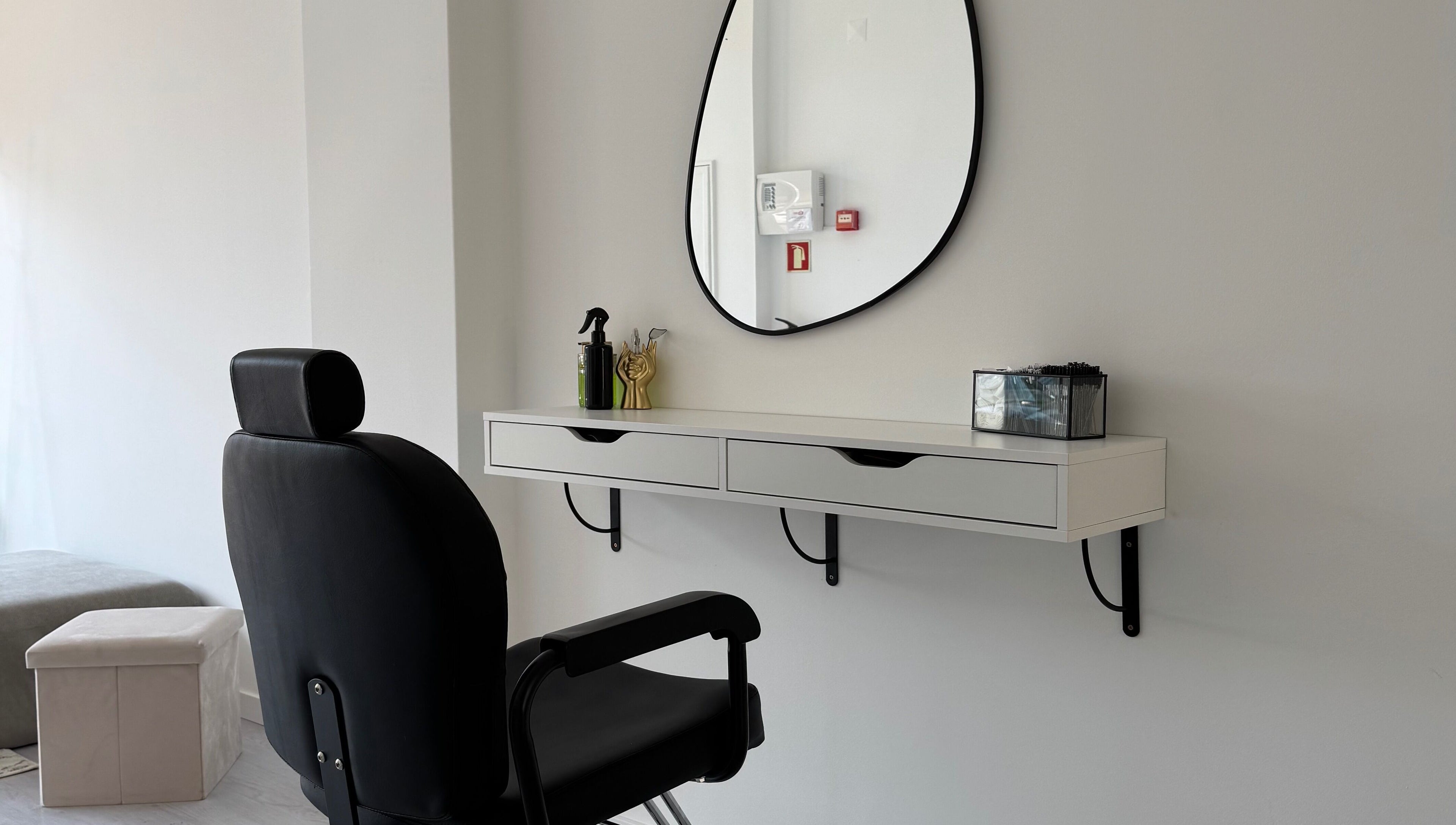Espaço de salão moderno em Juliana Nailstylist, Barcelos, Braga, PT, com espelho e cadeira preta.