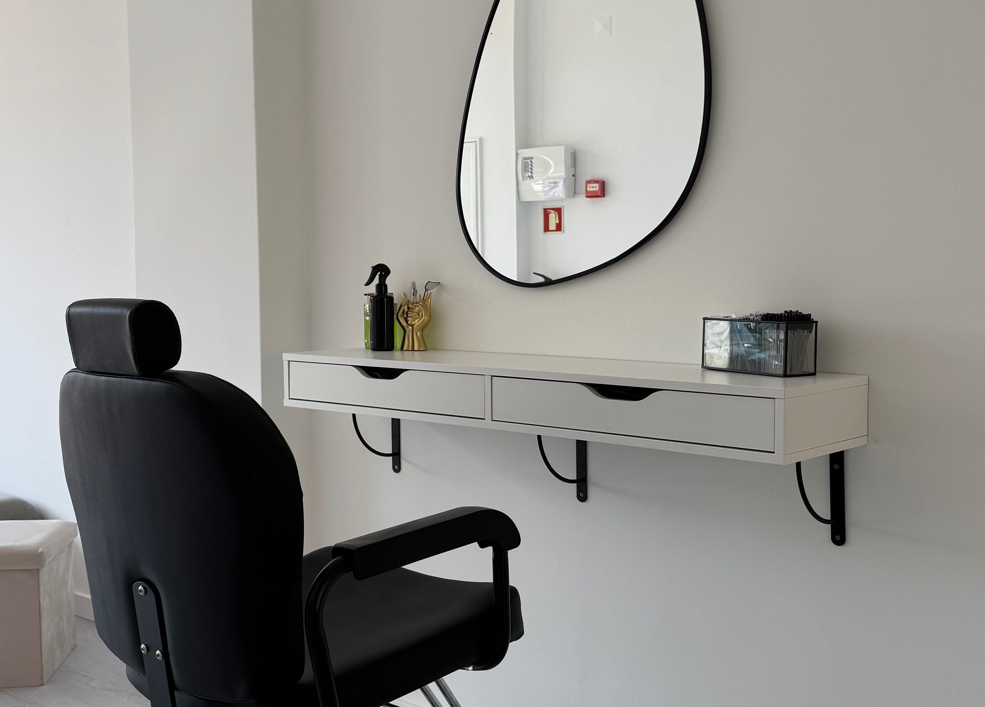 Espaço de salão moderno em Juliana Nailstylist, Barcelos, Braga, PT, com espelho e cadeira preta.