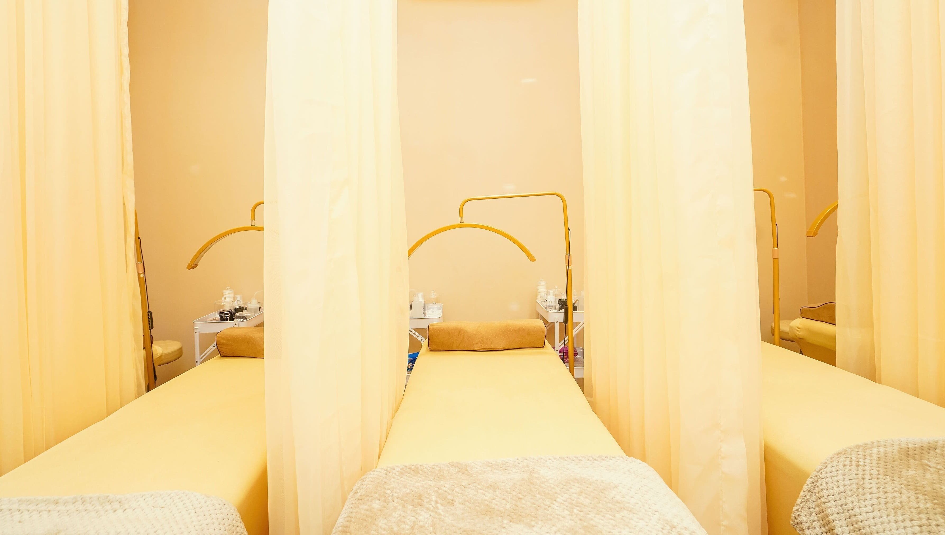 Peaceful Lash Room in Lagos, Lagos, NG showcasing comfortable treatment beds with soft yellow curtains.