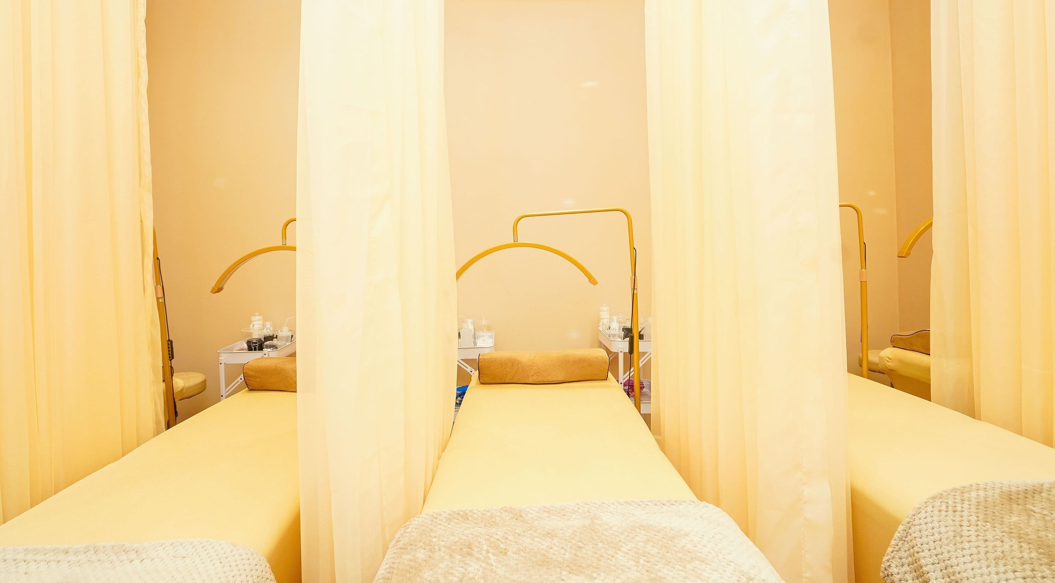 Peaceful Lash Room in Lagos, Lagos, NG showcasing comfortable treatment beds with soft yellow curtains.