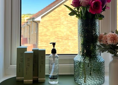 Elegant window setup at Neve Amelia Beauty, Daventry, England, GB with beauty products and floral decor.