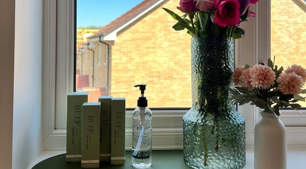 Elegant window setup at Neve Amelia Beauty, Daventry, England, GB with beauty products and floral decor.