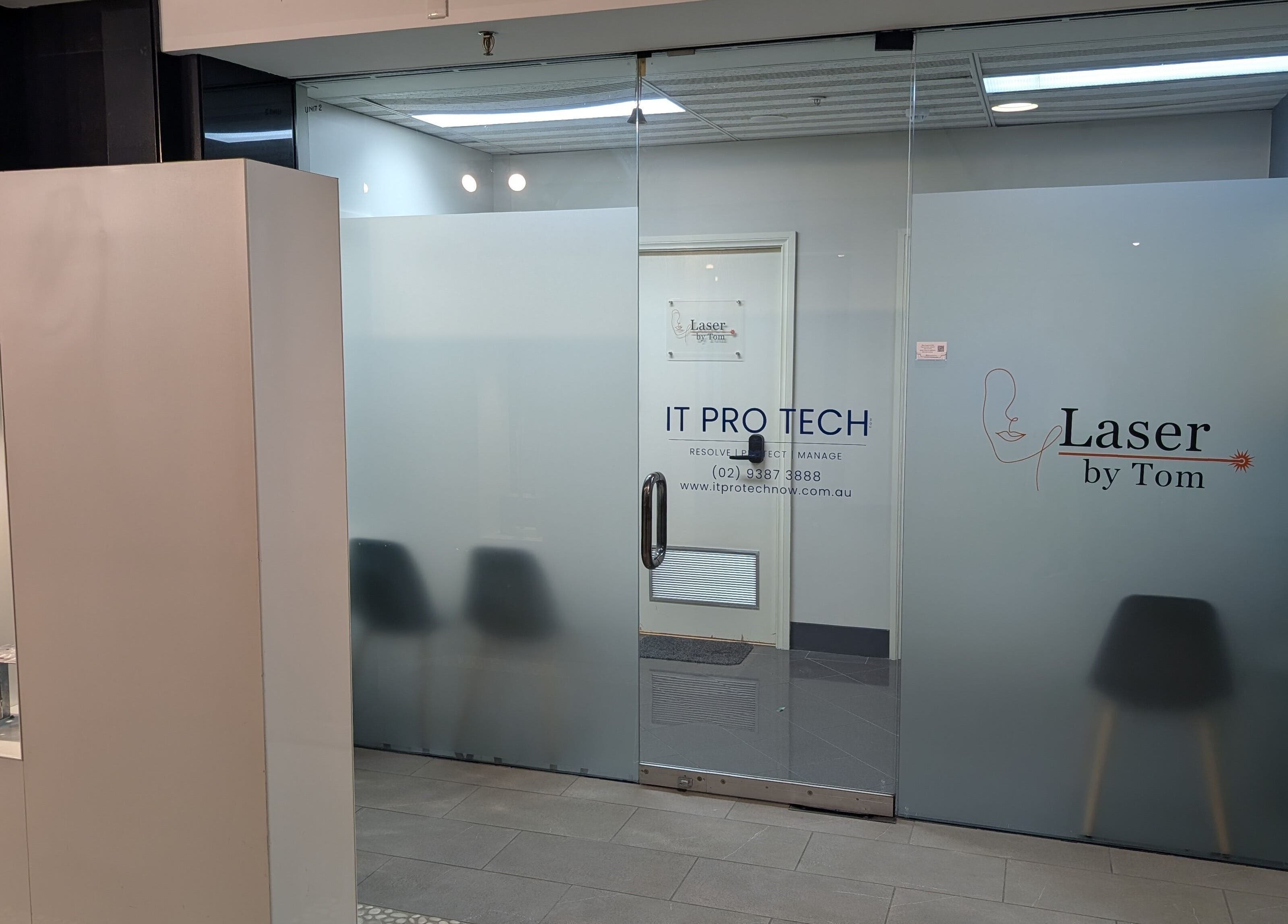 Entrance of Laser by Tom in Bondi Junction, New South Wales, AU, showcasing glass doors with signage.