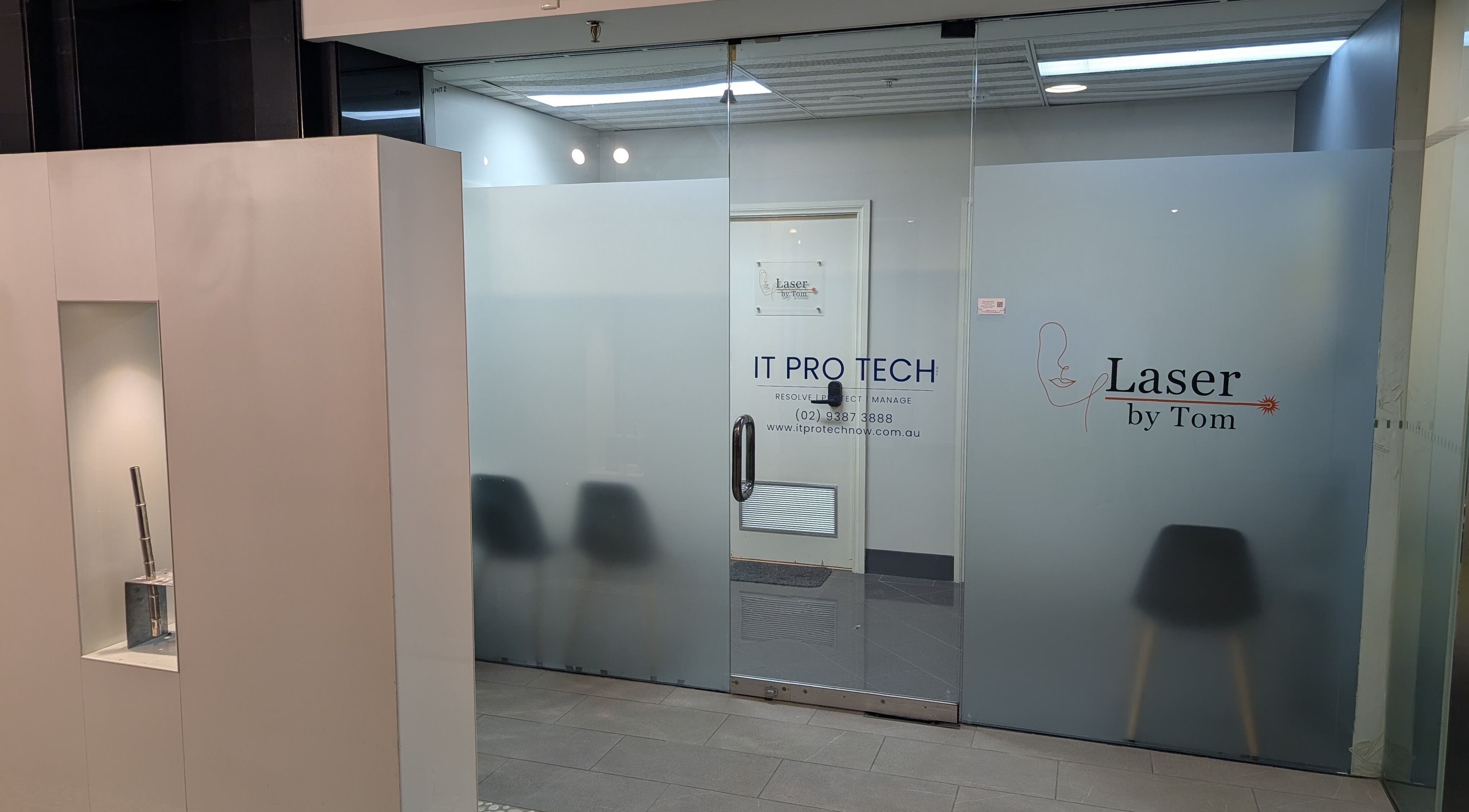 Entrance of Laser by Tom in Bondi Junction, New South Wales, AU, showcasing glass doors with signage.