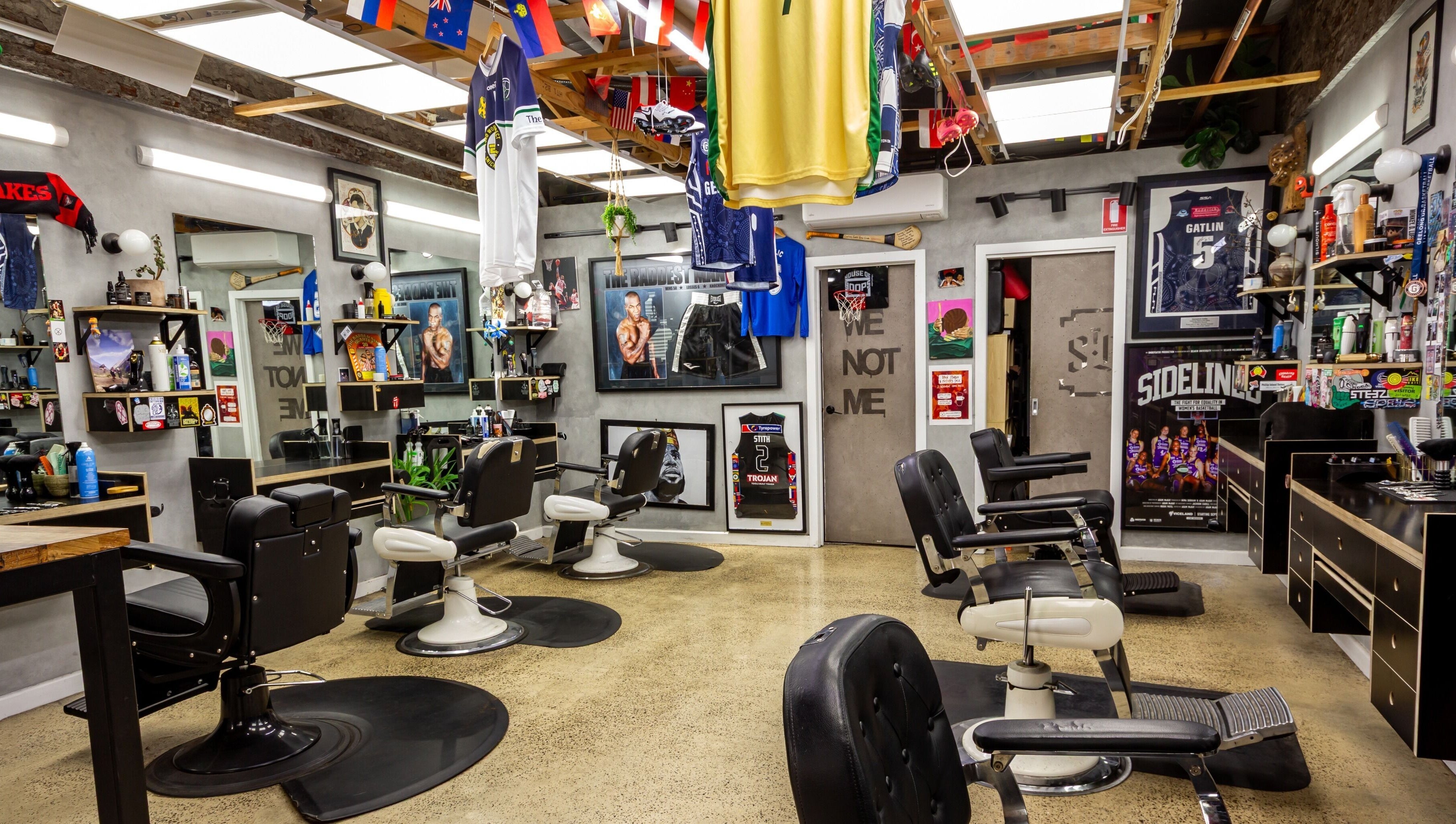 Interior of The Streets Barbershop in Geelong West, Victoria, AU, featuring vintage barber chairs and sports decor.