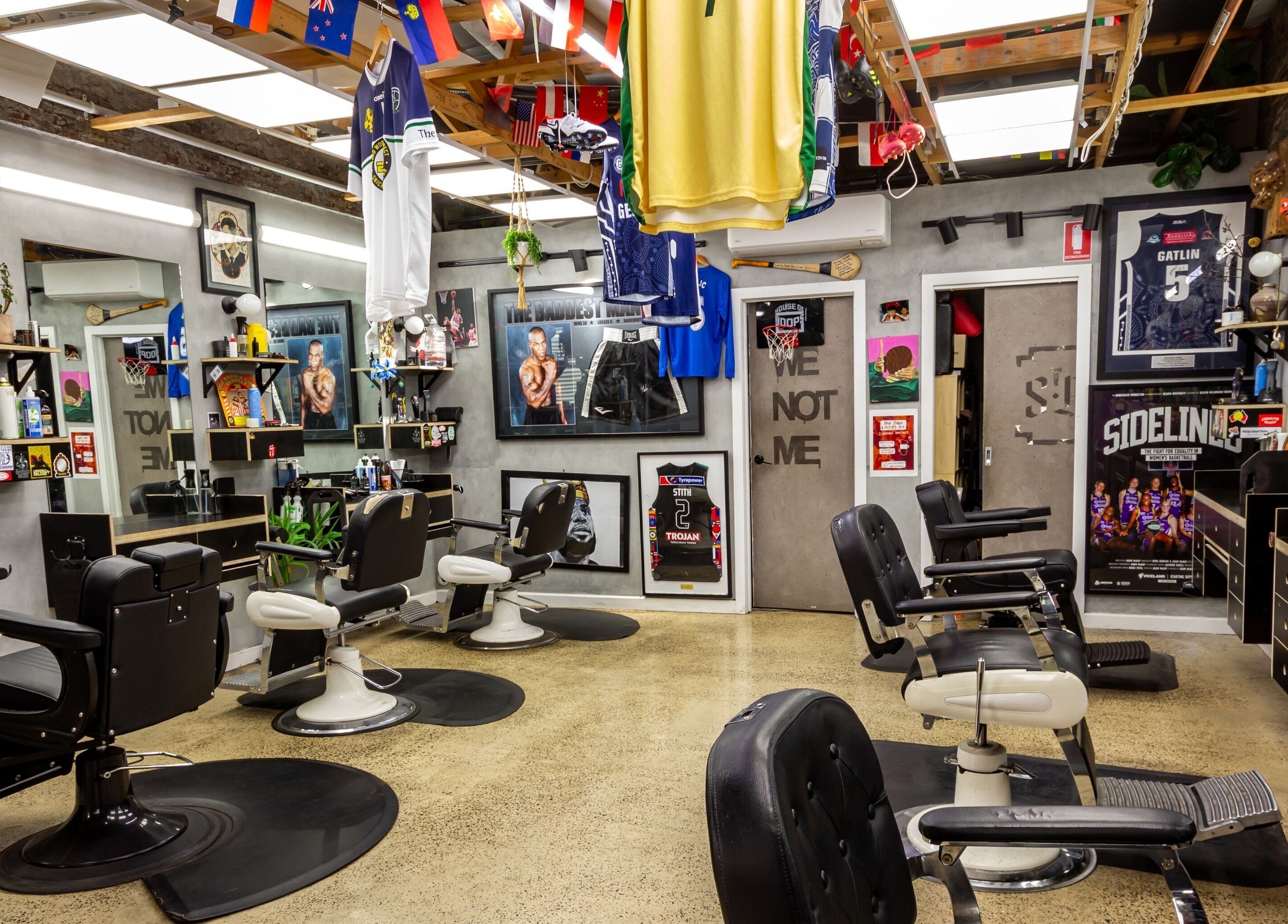 Interior of The Streets Barbershop in Geelong West, Victoria, AU, featuring vintage barber chairs and sports decor.