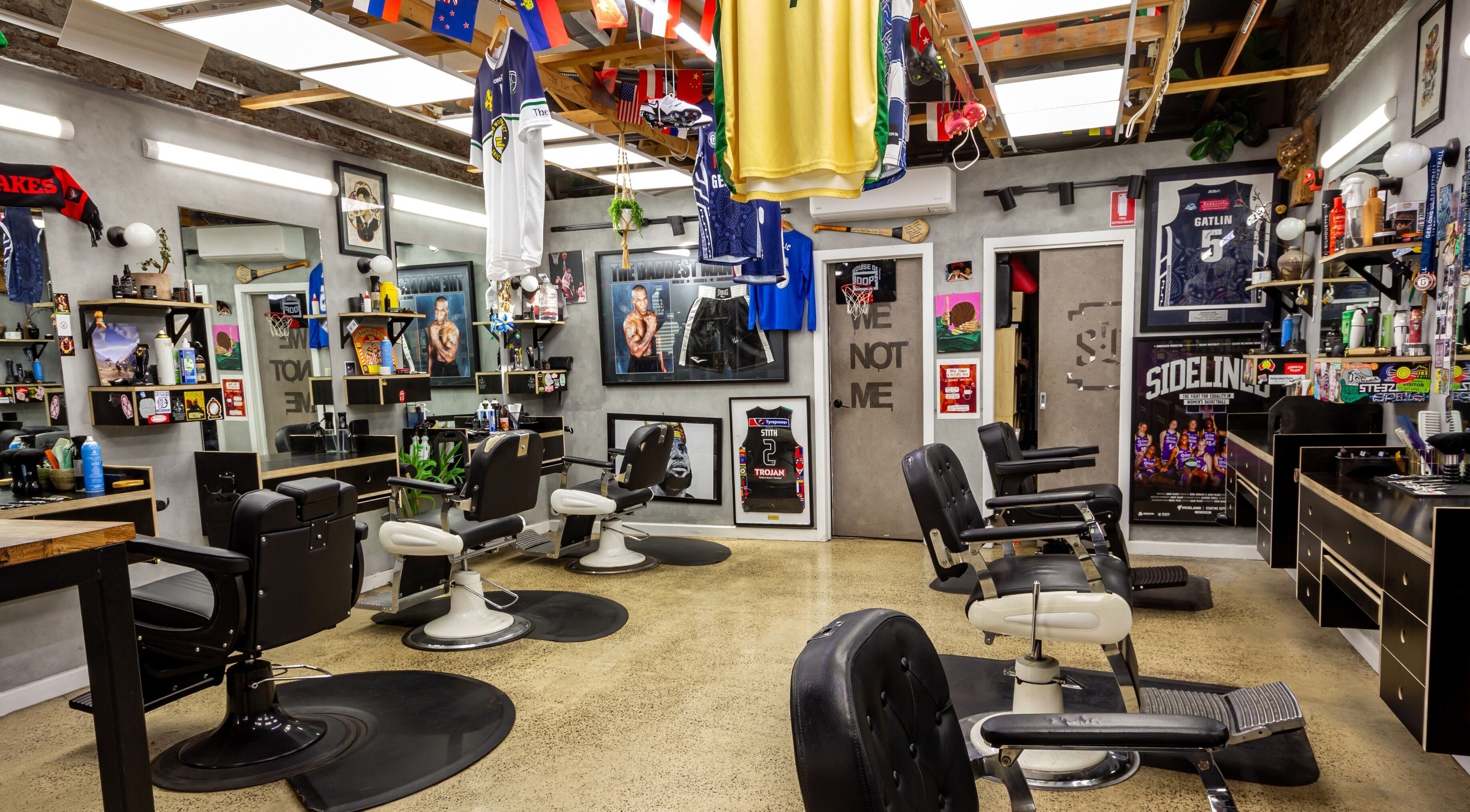 Interior of The Streets Barbershop in Geelong West, Victoria, AU, featuring vintage barber chairs and sports decor.