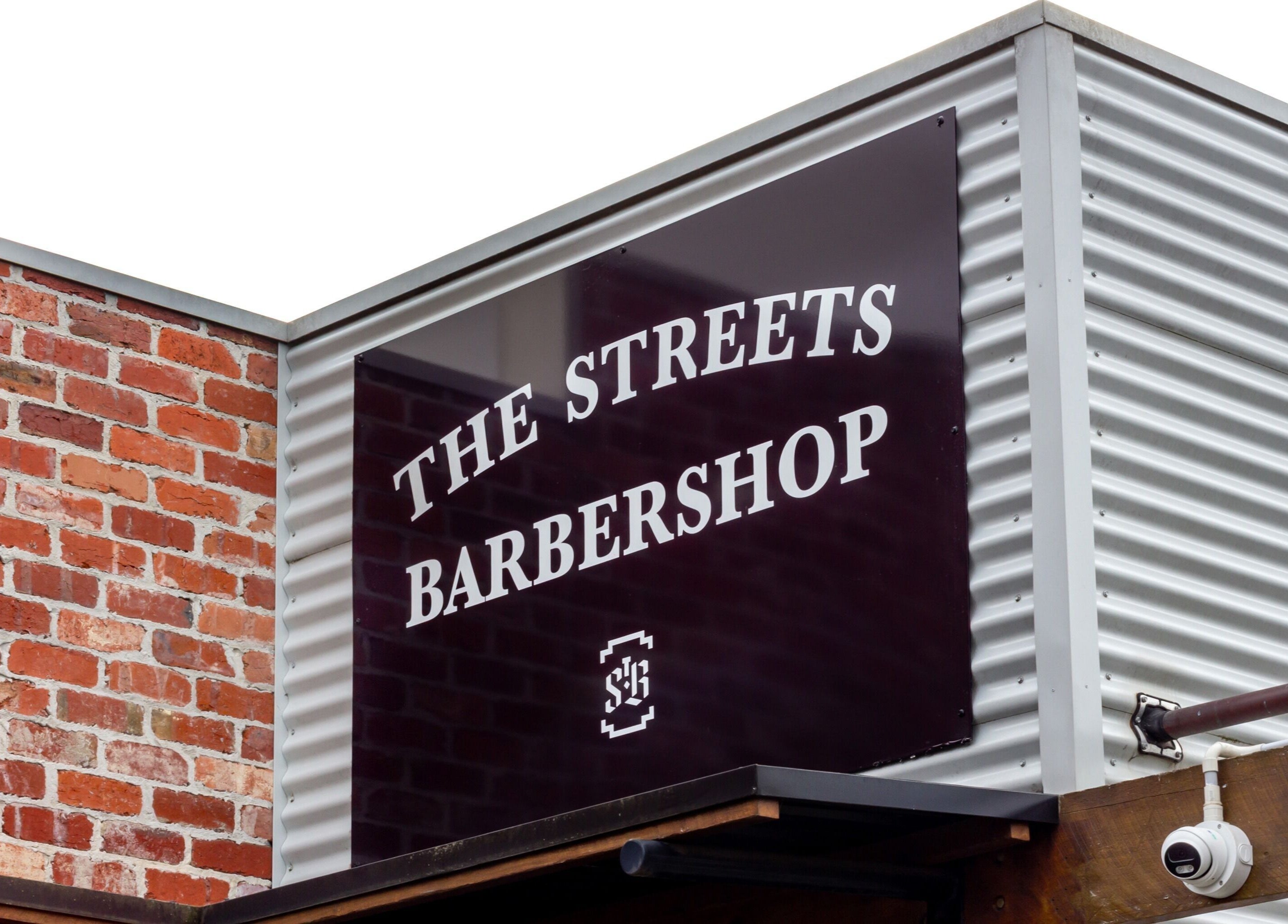 The Streets Barbershop facade in Geelong West, Victoria, AU, showcasing the stylish signage.