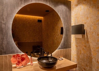 Interior acogedor de Sedatio by Cristina Aranda en Madrid, Comunidad De Madrid, ES, con espejo circular iluminado.