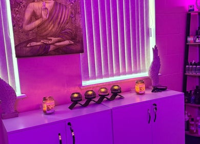 Calming purple-lit room at My Healing Hands, Burton Upon Trent, England, GB with Buddha decor and candles.