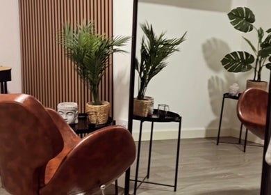 Relaxing spa corner at The Curl Station, Liverpool, England, GB featuring chairs, plants, and a Buddha statue.