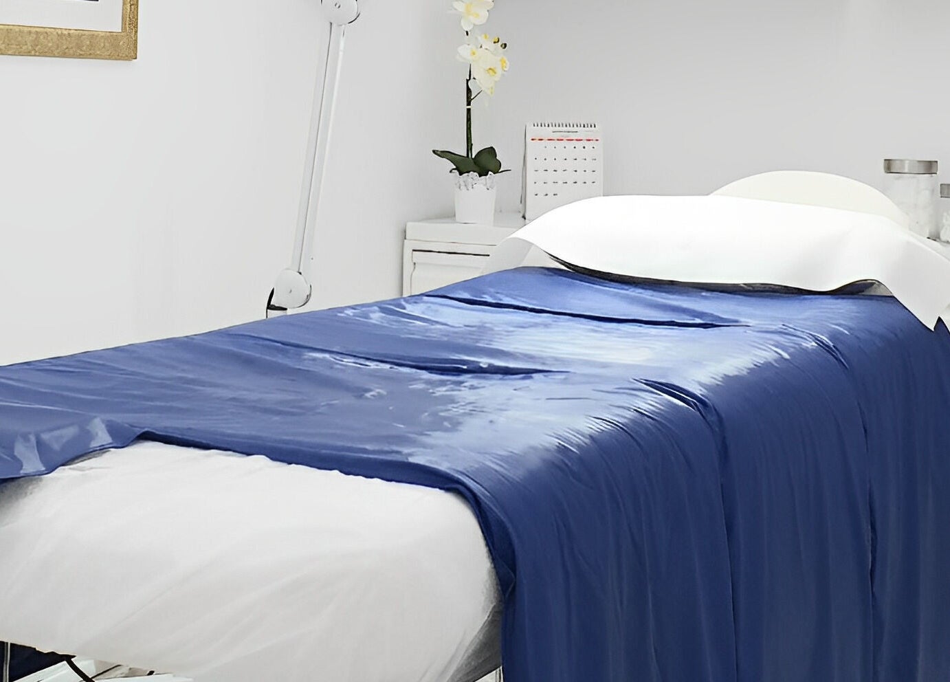 Sala de tratamiento en Lilium Beauty Bcn, Barcelona, Catalunya, ES con cama de spa azul.