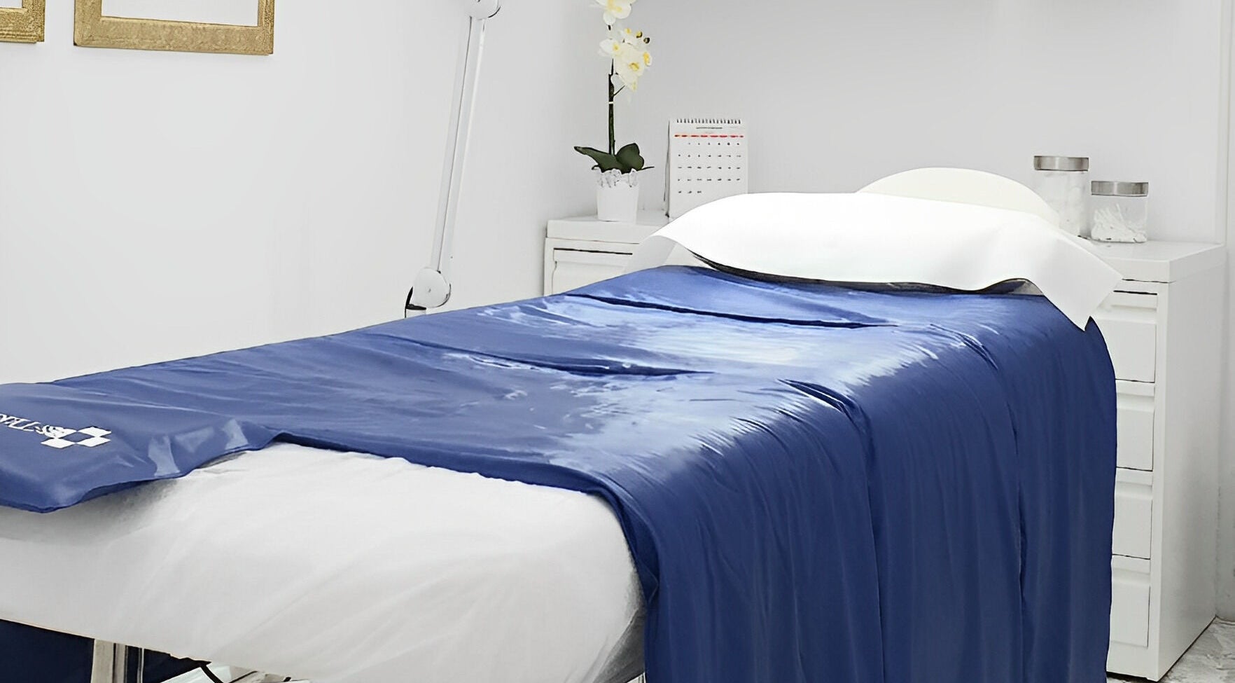 Sala de tratamiento en Lilium Beauty Bcn, Barcelona, Catalunya, ES con cama de spa azul.