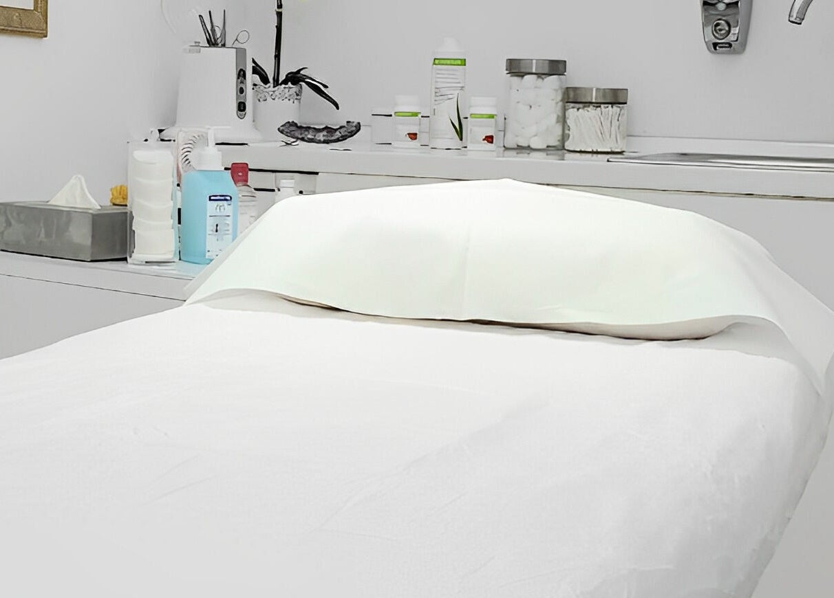 Sala de tratamiento en Lilium Beauty Bcn, Barcelona, Catalunya, ES, con cama blanca y productos de belleza.