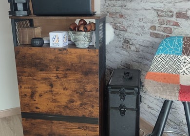 Intérieur chaleureux de Chez Sonia / A Chacun Ses Ongles à Moëlan-sur-mer, Bretagne, FR, avec chaise patchwork colorée.