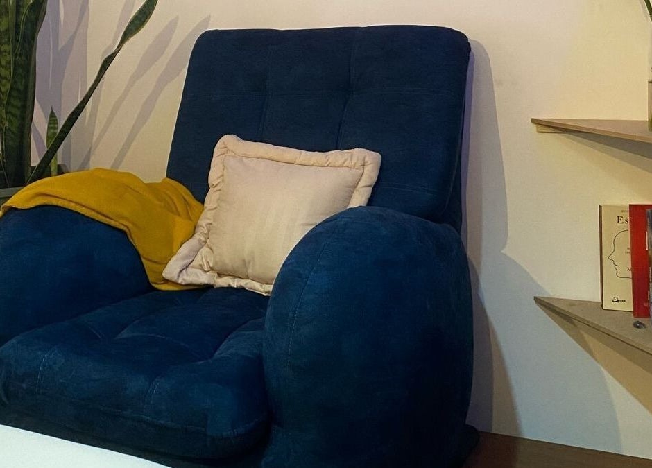 Sillón azul con cojín en Meraki-Harmony, Bogotá, Bogotá, CO. Ambiente relajante al lado de estantería.