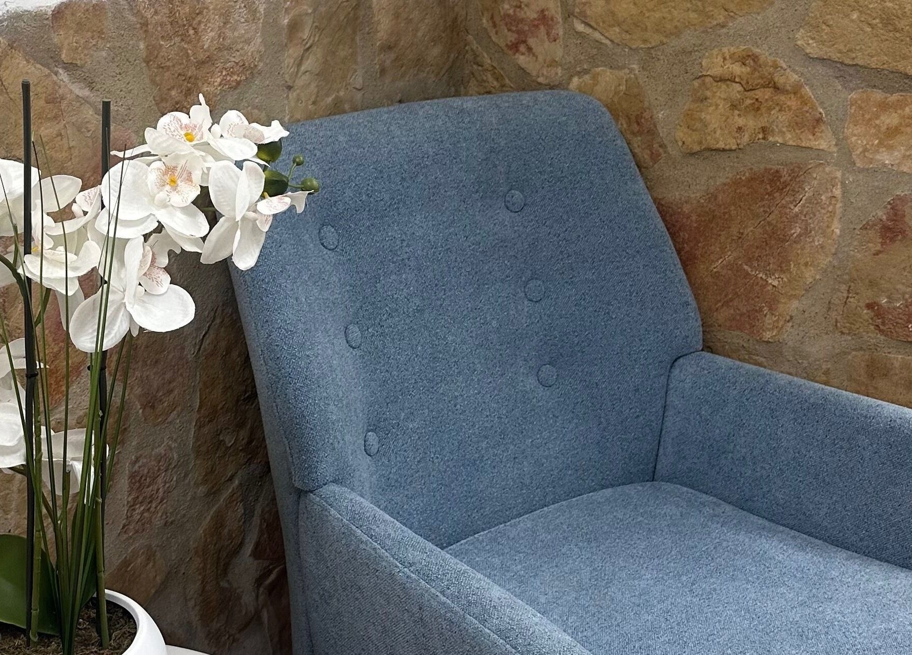 Sillón azul junto a flores blancas en HydroEstetic, València, Comunidad Valenciana, ES.