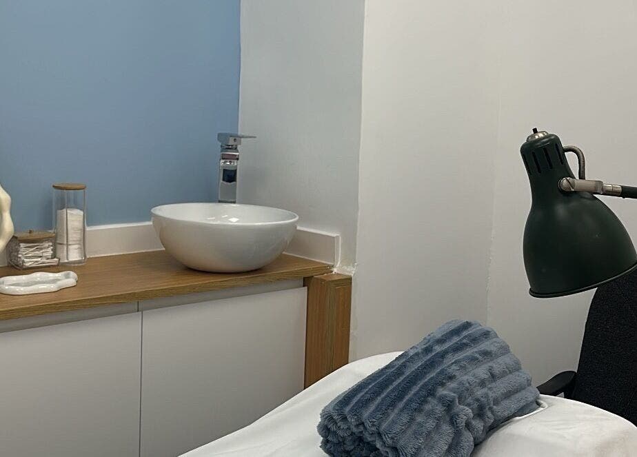 Sala de tratamiento relajante en HydroEstetic, València, Comunidad Valenciana, ES, equipada con lavabo y lámpara.