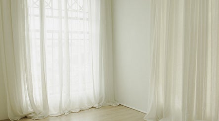 Sheer white curtains softly lit in The Light Loft, Hamilton, Waikato, NZ.