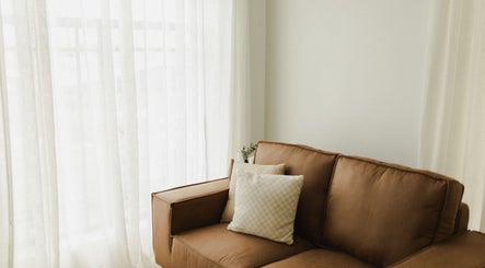 Elegant leather sofa by bright window at The Light Loft, Hamilton, Waikato, NZ.