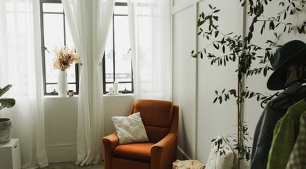 Bright and cozy nook at The Light Loft, Hamilton, Waikato, NZ with chair, pillow, and plants.
