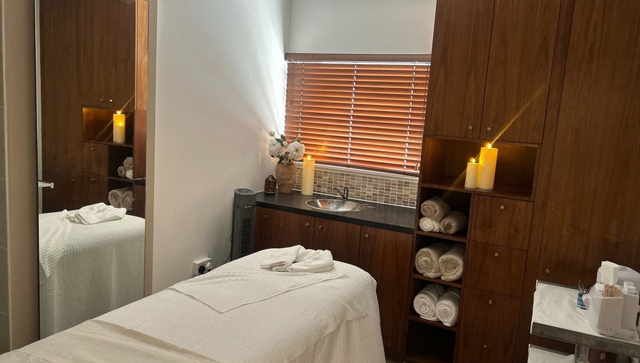 Relaxing treatment room at Tranquility By Catalin, Bridgend, Wales, GB, with candles and plush towels.