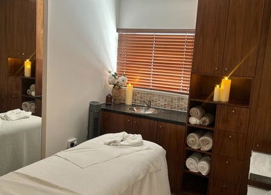 Relaxing treatment room at Tranquility By Catalin, Bridgend, Wales, GB, with candles and plush towels.