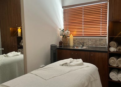 Spa treatment room at Tranquility By Catalin, Bridgend, Wales, GB with cozy setup and ambient lighting.