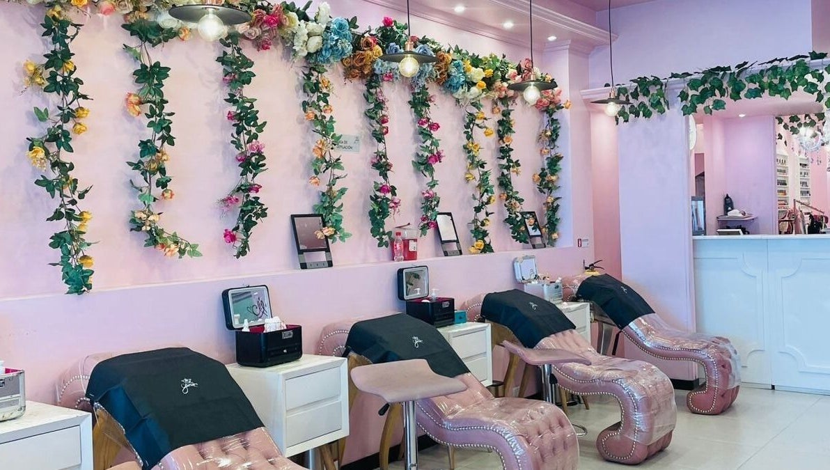 Elegante área de estética en Glam Spa Bogotá - Sede Restrepo con paredes florales y sillones rosados, Bogotá, D.c., CO.