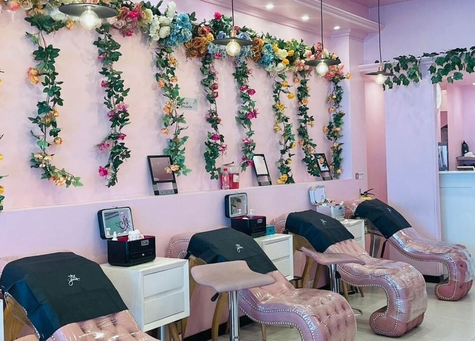 Elegante área de estética en Glam Spa Bogotá - Sede Restrepo con paredes florales y sillones rosados, Bogotá, D.c., CO.