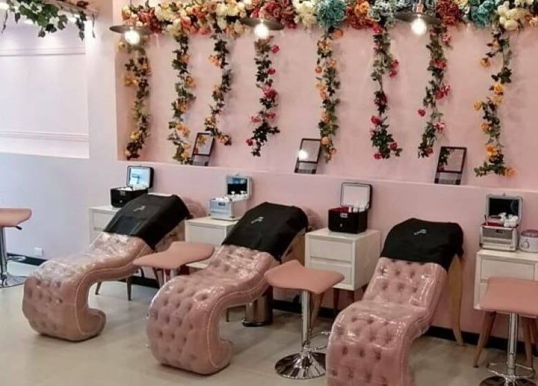 Interior de Glam Spa Bogota - Sede Restrepo en Bogotá, D.c., CO con elegantes sillas de masaje y decoración floral.