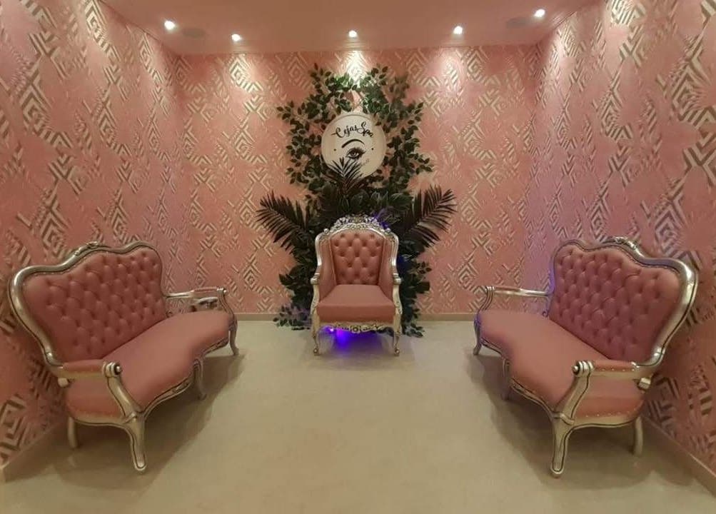Elegante sala de espera en Glam Spa Bogotá- Sede Modelia, Bogotá, D.c., con asientos rosados y fondo decorativo.
