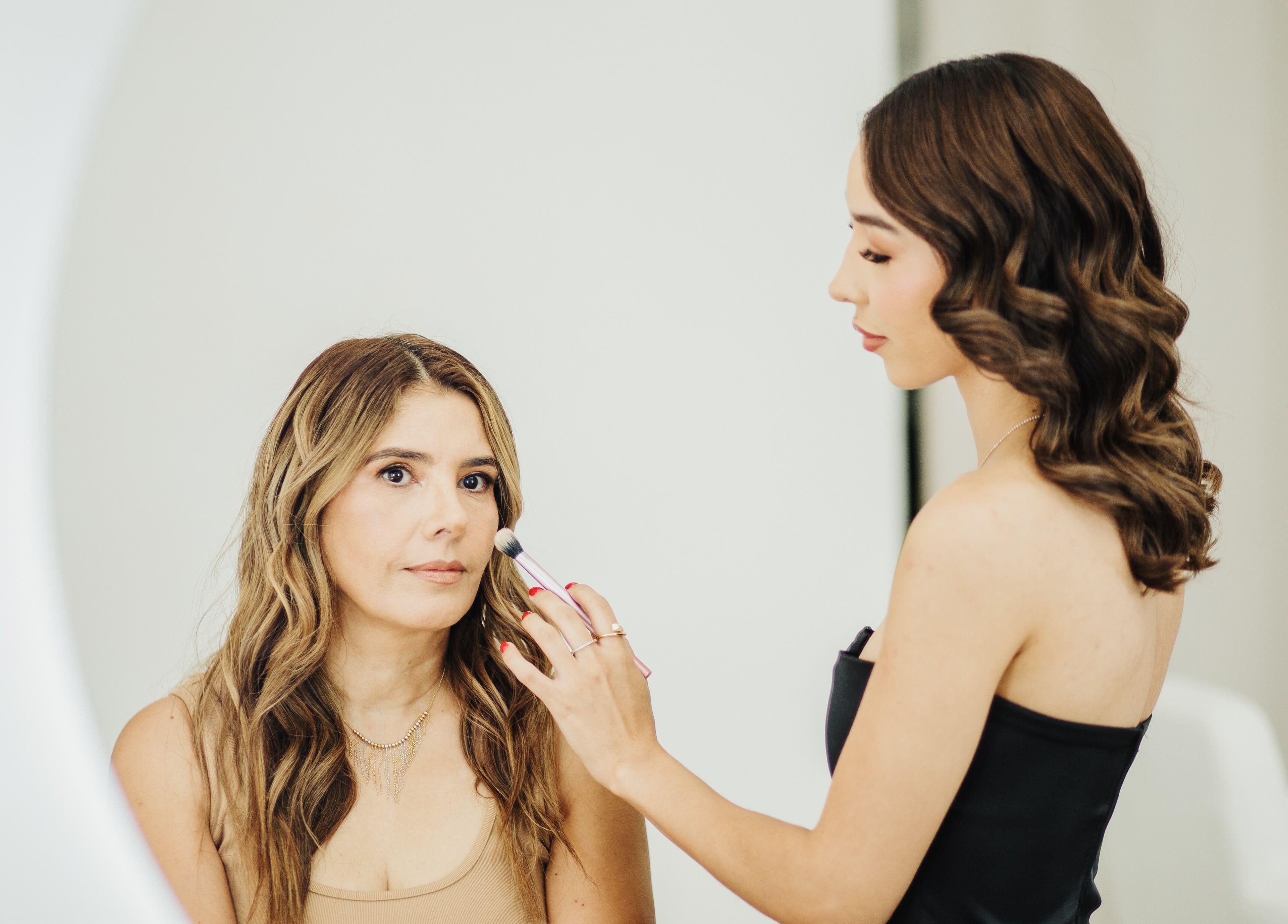 Artista de maquillaje en Aura Beauty, Saltillo, Coahuila De Zaragoza, MX, aplicando sombra a cliente.