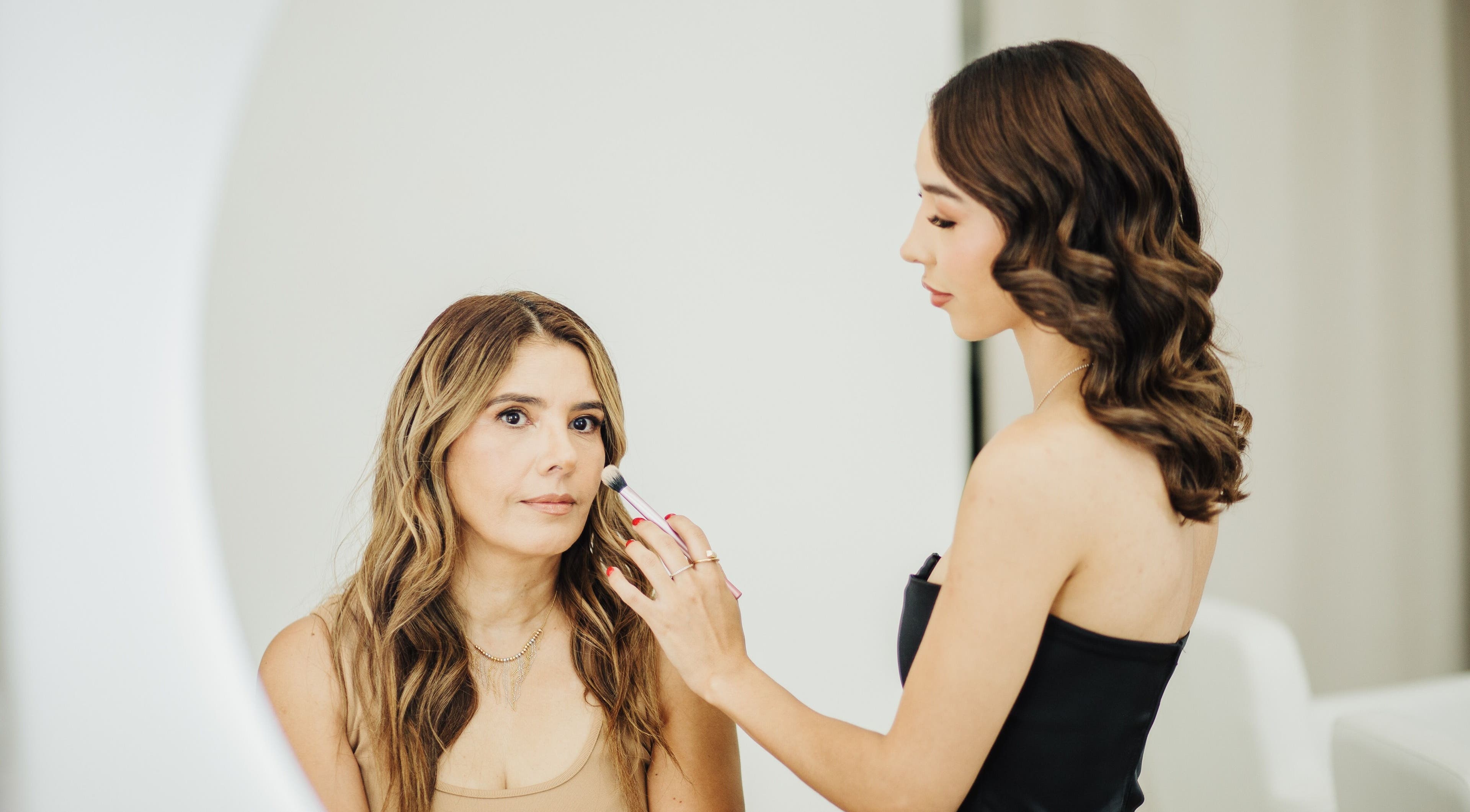 Artista de maquillaje en Aura Beauty, Saltillo, Coahuila De Zaragoza, MX, aplicando sombra a cliente.